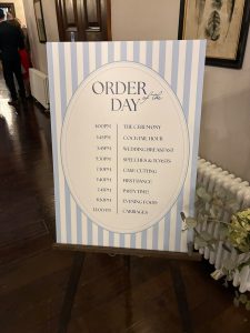 Printed wedding order of the day sign on an easel